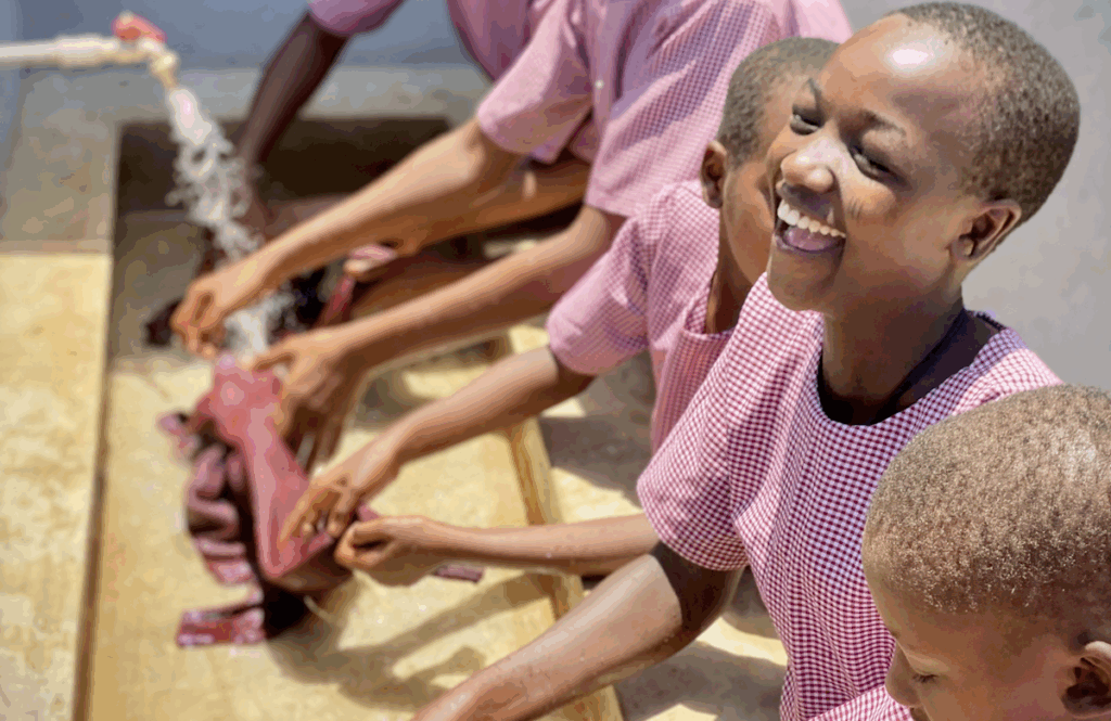 A group of girls working in front of a water trough