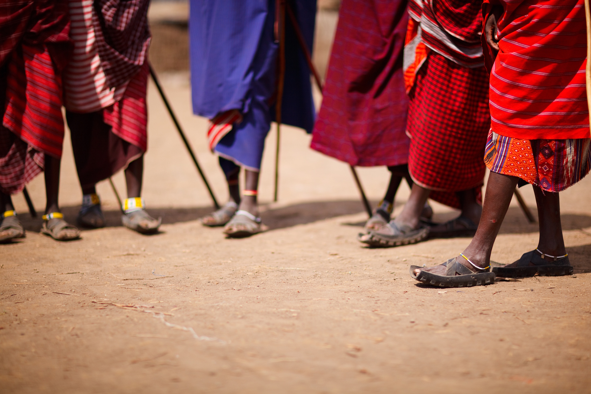 Closeup of a group of people wearing traditional clothing and sandals.