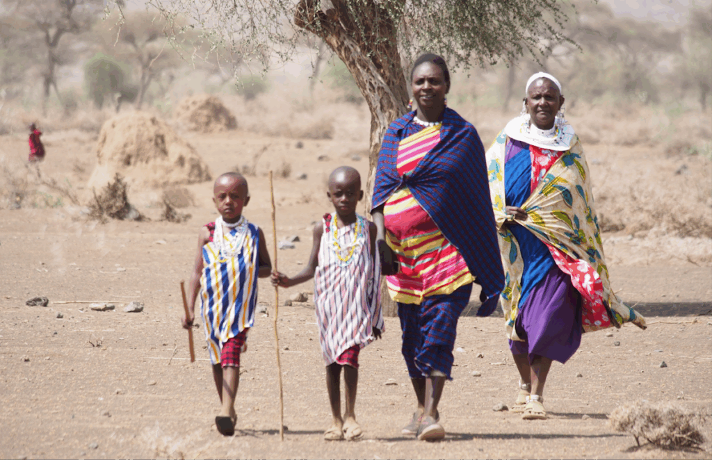 Two adults and two children walking across a desert