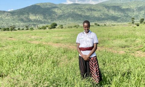 A person standing in an open field of grass