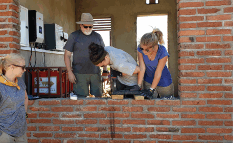 People working in an open window in a brick wall