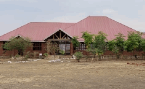 A large building with a pitched roof and trees in front of it