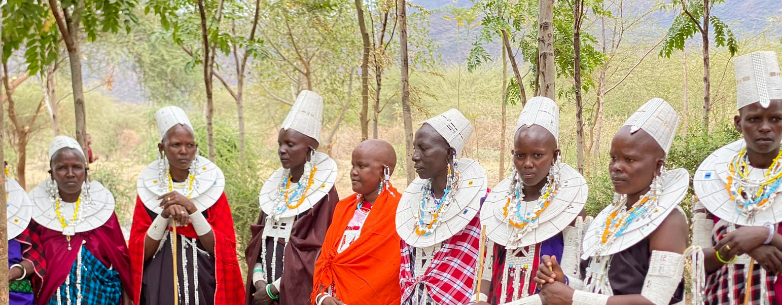A group of people in traditional clothing standing in a line outside